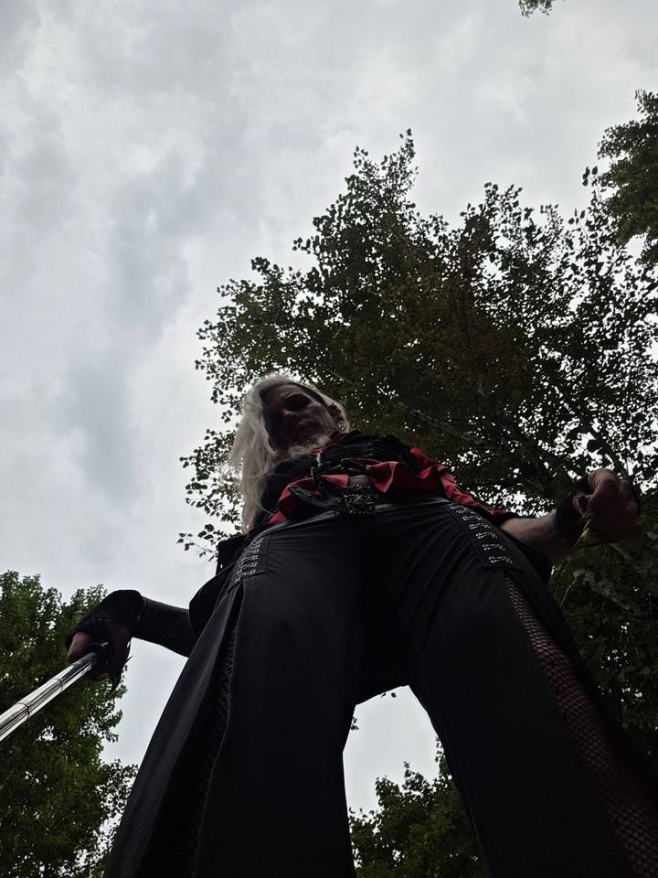 A person standing under trees in soft daylight, seen from below